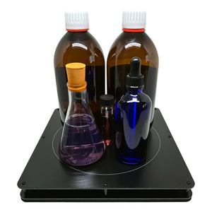 The XL Radionic Extension Plate shown with a selection of bottles to demonstrate its 5L capacity for garden and large-scale radionic treatments.